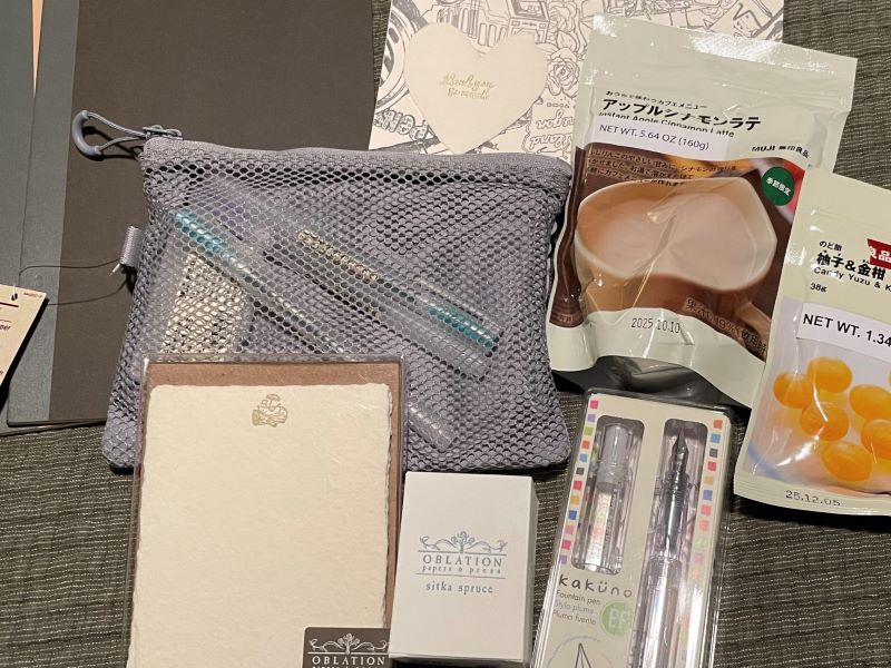 Notebooks, pens, a zipper pouch and snacks from MUJI; a fountain pen, blank note cards and a bottle of custom ink from Oblation Papers.